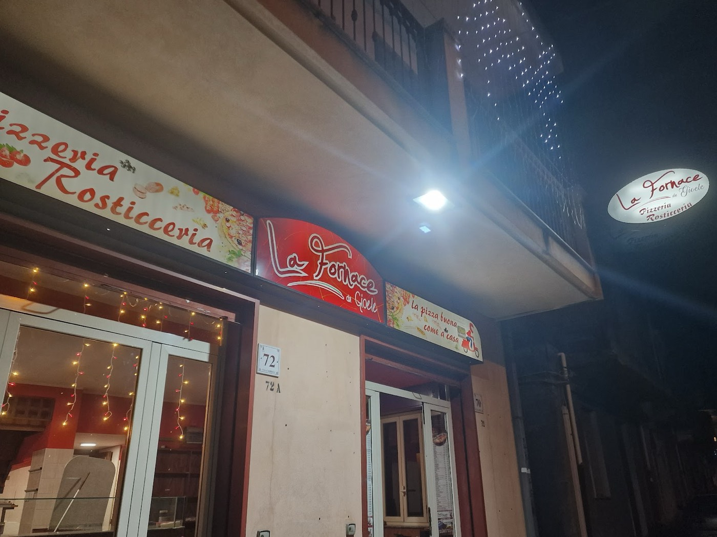La facciata e l'insegna rossa di La Fornace da Gioele in Via Cairoli, la sera
