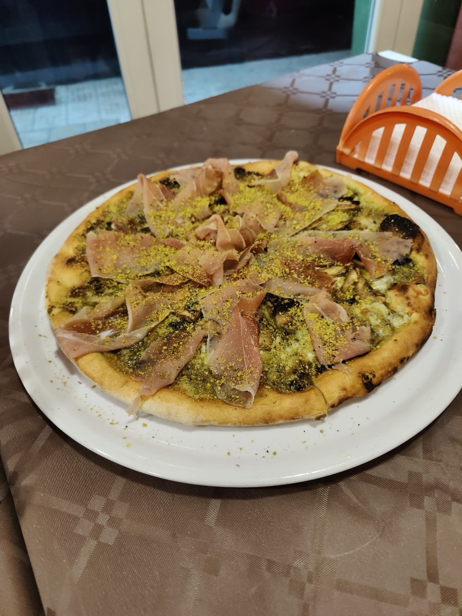 Pizza al pistacchio con speck e granella, servita a La Fornace da Gioele